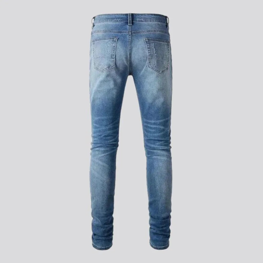 Damaged men's whiskered jeans